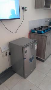 a small refrigerator in the corner of a kitchen at Gloria's homes in Mtwapa
