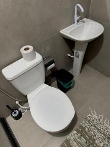 a bathroom with a white toilet and a sink at Flats super bem localizado! in Arraial do Cabo