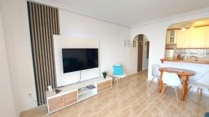 a living room with a television and a table and chairs at Arenales Sea View Apartment in Arenales del Sol +33 photos