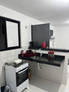 a kitchen with a stove and a sink and a window at Flats super bem localizado! in Arraial do Cabo