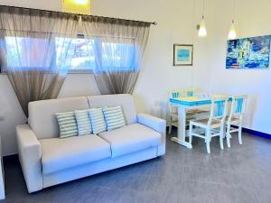 ein Wohnzimmer mit Sofa und Tisch in der Unterkunft Villa Corallo con vista mozzafiato in Costa Paradiso