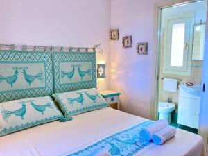 Schlafzimmer mit einem Bett mit blauen und grünen Akzenten in der Unterkunft Villa Corallo con vista mozzafiato in Costa Paradiso