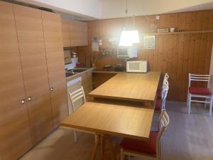 a kitchen with a wooden table and a microwave at Sole Alto 85 in Mezzana +5 photos