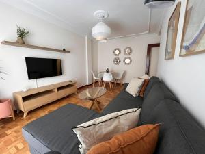 a living room with a couch and a flat screen tv at Otto's Home Horizonte in Lastres