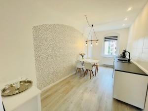 a kitchen and dining room with a table and chairs at Mitten in Meißen moderne Ferienwohnung No 5 in Meißen +3 photos