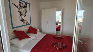 een kamer met een bed met rode kussens en een spiegel bij CRYSTAL WAVE Apartments in Novalja +38 foto's