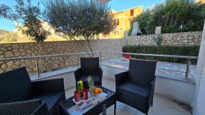 een patio met 2 stoelen en een tafel met een pompoen bij CRYSTAL WAVE Apartments in Novalja