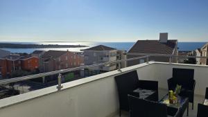 een balkon met een tafel en stoelen en de oceaan bij CRYSTAL WAVE Apartments in Novalja
