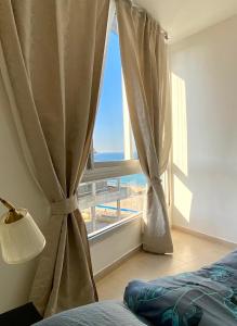 una camera da letto con finestra con vista sull'oceano di bat-yam 2 Bedrooms on the beach a Bat Yam