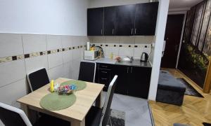 a kitchen with a wooden table and a table and chairs at Apartman Teddy12-Vlašić in Vlasic