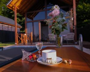 a table with a cup and a vase of flowers at Bell Garden Maşukiye in Kocaeli