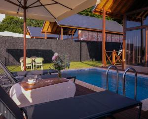 a patio with a table and an umbrella next to a pool at Bell Garden Maşukiye in Kocaeli
