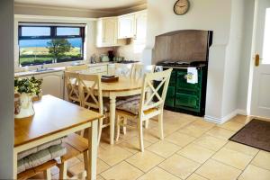 a kitchen and dining room with a table and chairs at Sea View Farmhouse in Cushendun