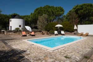 a pool in a yard with chairs and a building at Moinho do Avo To in Rio Maior