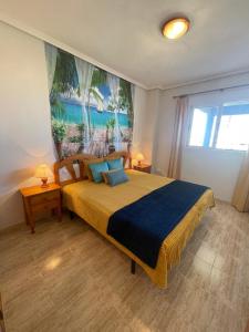 a bedroom with a large bed with a painting on the wall at Arenales Sea View Apartment in Arenales del Sol