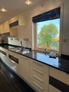 a kitchen with a black counter top and a window at North apartments Tromsø 5 in Tromsø