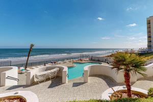 a resort with a swimming pool next to the beach at Peaceful Paradise in Daytona Beach Shores