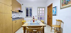 a kitchen with a table with a bottle of wine on it at Cichello Apartament in Ricadi