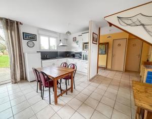 a kitchen and dining room with a table and chairs at Maison cosy avec grand jardin in Saint-Avé +30 photos