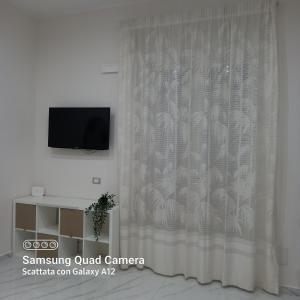 a white curtain in a room with a tv at Jenny's house in Castellammare di Stabia