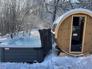 a wooden hot tub in the snow in the woods at Villa Yarema Mountain Relax with Hot Jacuzzi & Sauna by BookVillaBG in Zheleznitsa