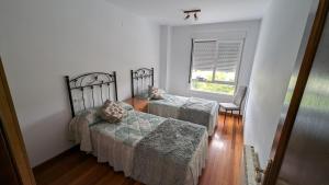 Un dormitorio con dos camas y una ventana. en Alojamiento La Caridad, en La Caridad