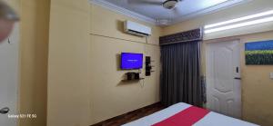 een slaapkamer met een bed en een tv aan de muur bij One Bedroom studio apartment with kitchen in Karachi