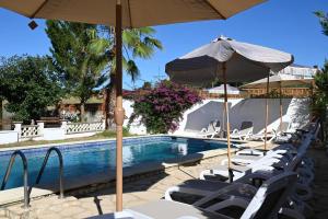 a swimming pool with lounge chairs and an umbrella at Villa de Gracia Casa 2 in Tordera