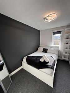 a bedroom with a bed with a black blanket at 2 Bed Apartment in Greenwich, Free Parking, DLR in London