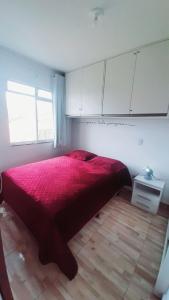 a bedroom with a large red bed and a window at 15 minutos da praia ExpocentroCentro Greenvaley in Camboriú