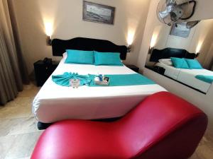 a bedroom with a large bed and a red chair at Hostal Lince in Lima