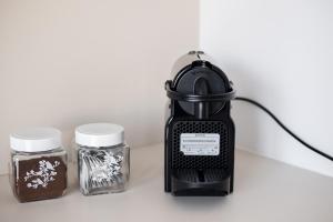 a black blender next to two jars of food at MyPlace Caramel Apartment Sandomierz in Sandomierz