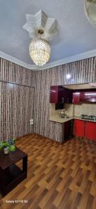 een woonkamer met houten vloeren en een kroonluchter bij One Bedroom studio apartment with kitchen in Karachi +7 foto's
