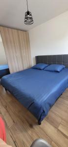 - un lit dans une chambre avec une couette bleue dans l'établissement Agréable maison familiale, à Carcans 12 autres photos