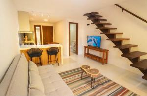 a living room with a couch and a spiral staircase at Morro de São Paulo- Quarta Praia - Casa Bethel in Cairu