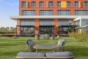 um edifício com cadeiras e uma mesa em frente em Courtyard by Marriott Dakar Diamniadio em Dakar