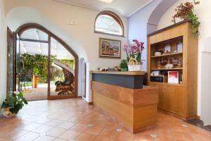 a lobby with an archway and a counter with flowers at Relais Villa Angiolina in Sorrento