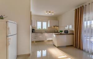 a kitchen with white cabinets and a refrigerator at 2 Bedroom Stunning Home In Skatari in Šikići