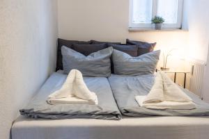 a bed with pillows and towels on top of it at Ferienwohnung am Neuen Thore I in Blankenburg