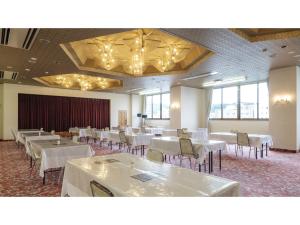 延岡市にあるNobeoka Royal Hotel - Vacation STAY 24870vの白いテーブルと椅子が置かれた宴会場