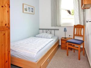 a bedroom with a bed and a chair and a window at Appartementhaus, Zinnowitz in Zinnowitz