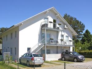 two cars parked in front of a white house at Appartementhaus, Zinnowitz in Zinnowitz