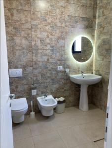 a bathroom with a sink and a toilet and a mirror at Hadri-rooms in Korçë +27 photos