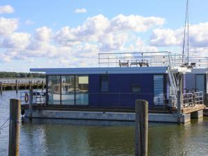 里布尼茨达姆加滕Houseboat in Ribnitz near Amber Museum的水面上码头上的房屋