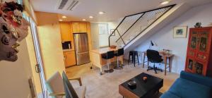 a living room with a staircase and a kitchen with a table at Intimate Townhome Sanctuary DT in Albuquerque