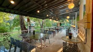 a patio with tables and chairs on a balcony at Beachwood Mansion Nagaon in Nagaon