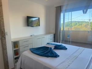 a bedroom with a bed with a tv and a window at Pérola de Geribá in Búzios +84 photos