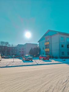 una strada innevata con auto parcheggiate di fronte agli edifici di Eerikinkadun Helmi a Salo