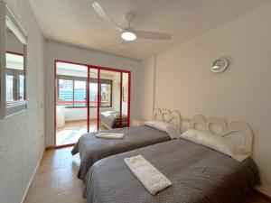 um quarto com duas camas e um ventilador de teto em Loixmar 7 em Benidorm mais 23 fotografias