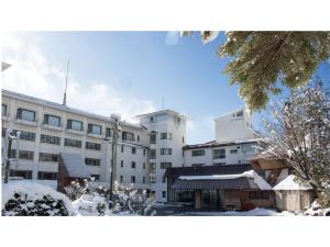 a large white building with snow in front of it at Villa Inawashiro - Vacation STAY 27678v in Inawashiro